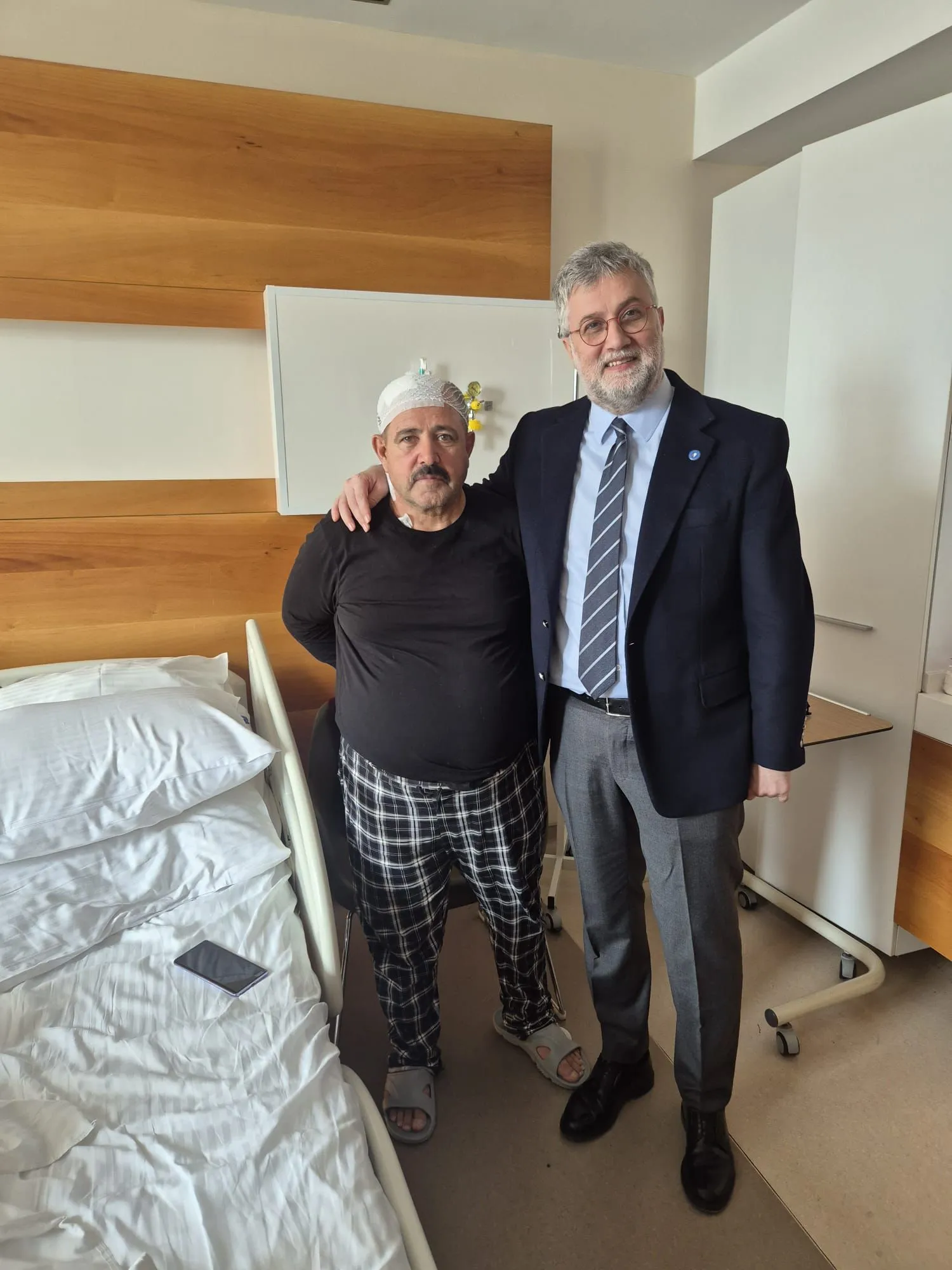Patient standing with Prof. Dr. Kocabicak after successful DBS surgery